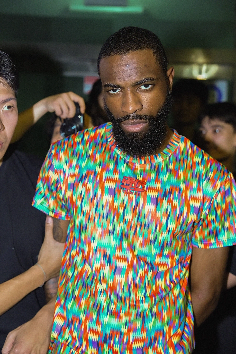 A flash-lit portrait in a multicoloured T-shirt