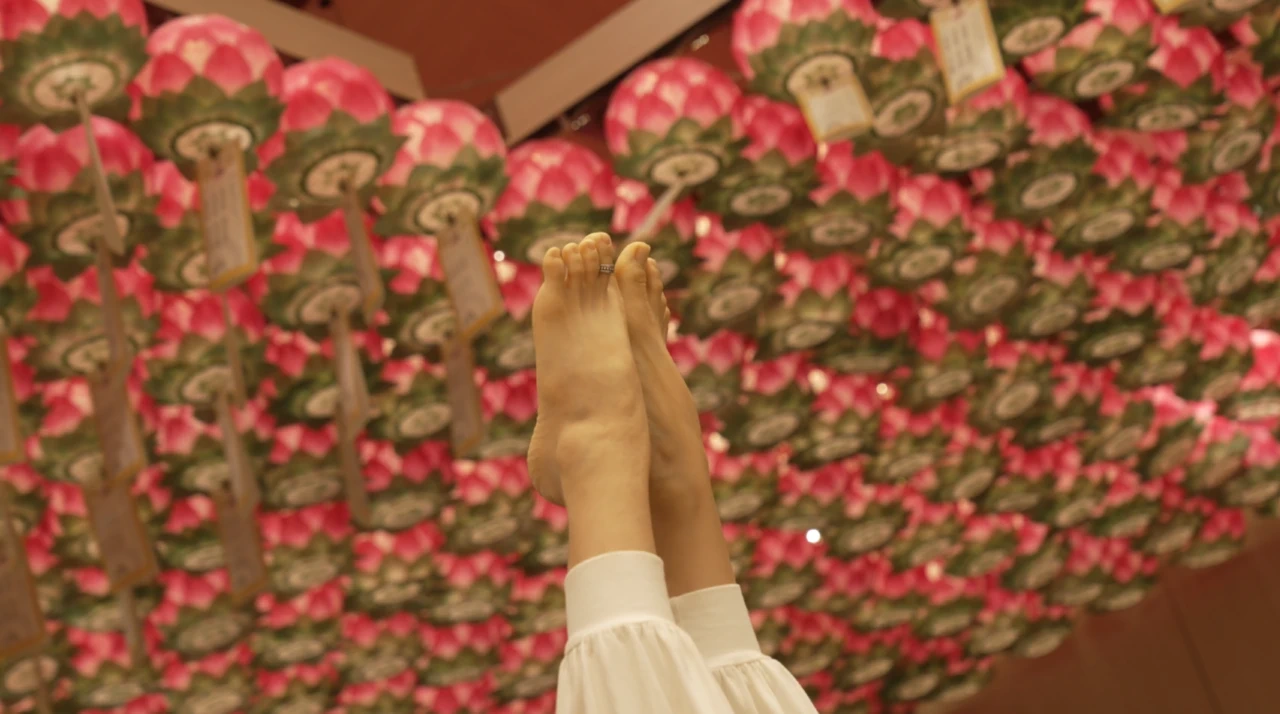 Two feet reaching toward colourful lanterns