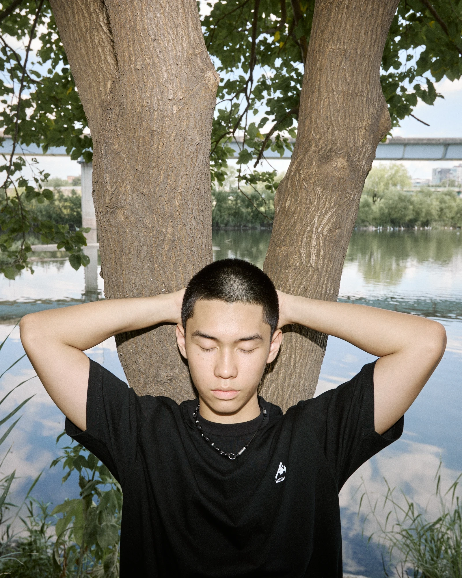 A portrait beneath a tree beside the river