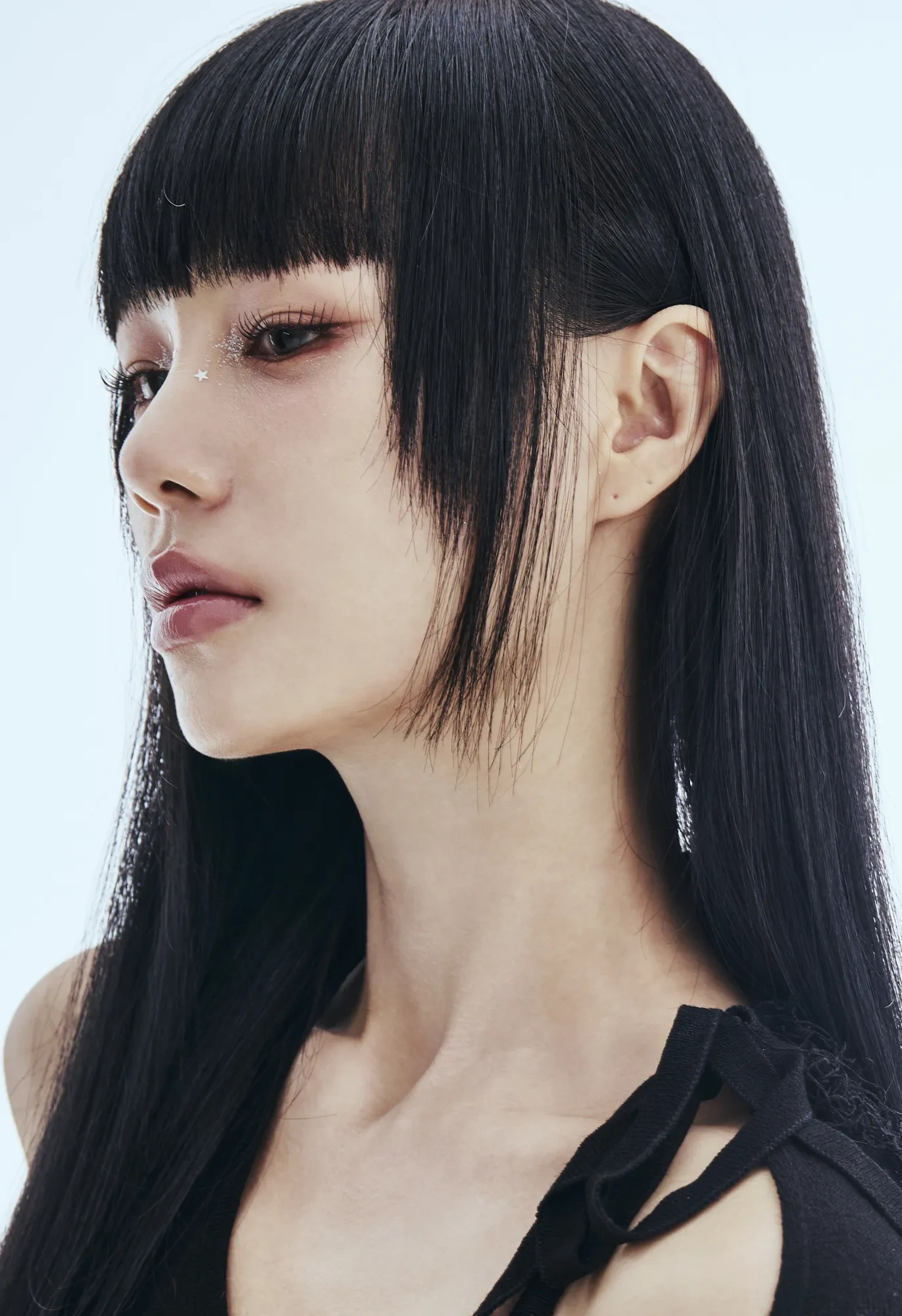 A portrait in profile against pale blue