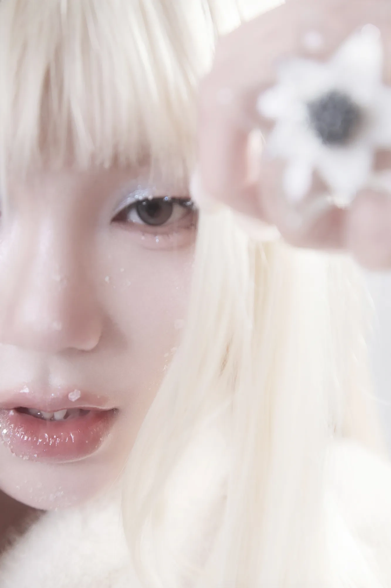 A pale close-up framed by soft blonde hair